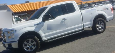 Sample CarGo still: a white Ford F-150 arriving at a job site, lettering blurred