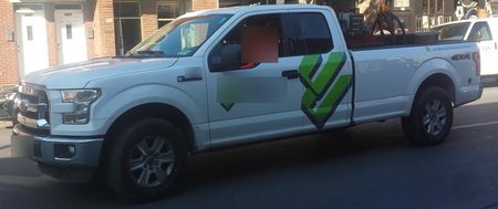 Sample CarGo still: a white Ford F-150 in profile on a residential street, plate and driver blurred